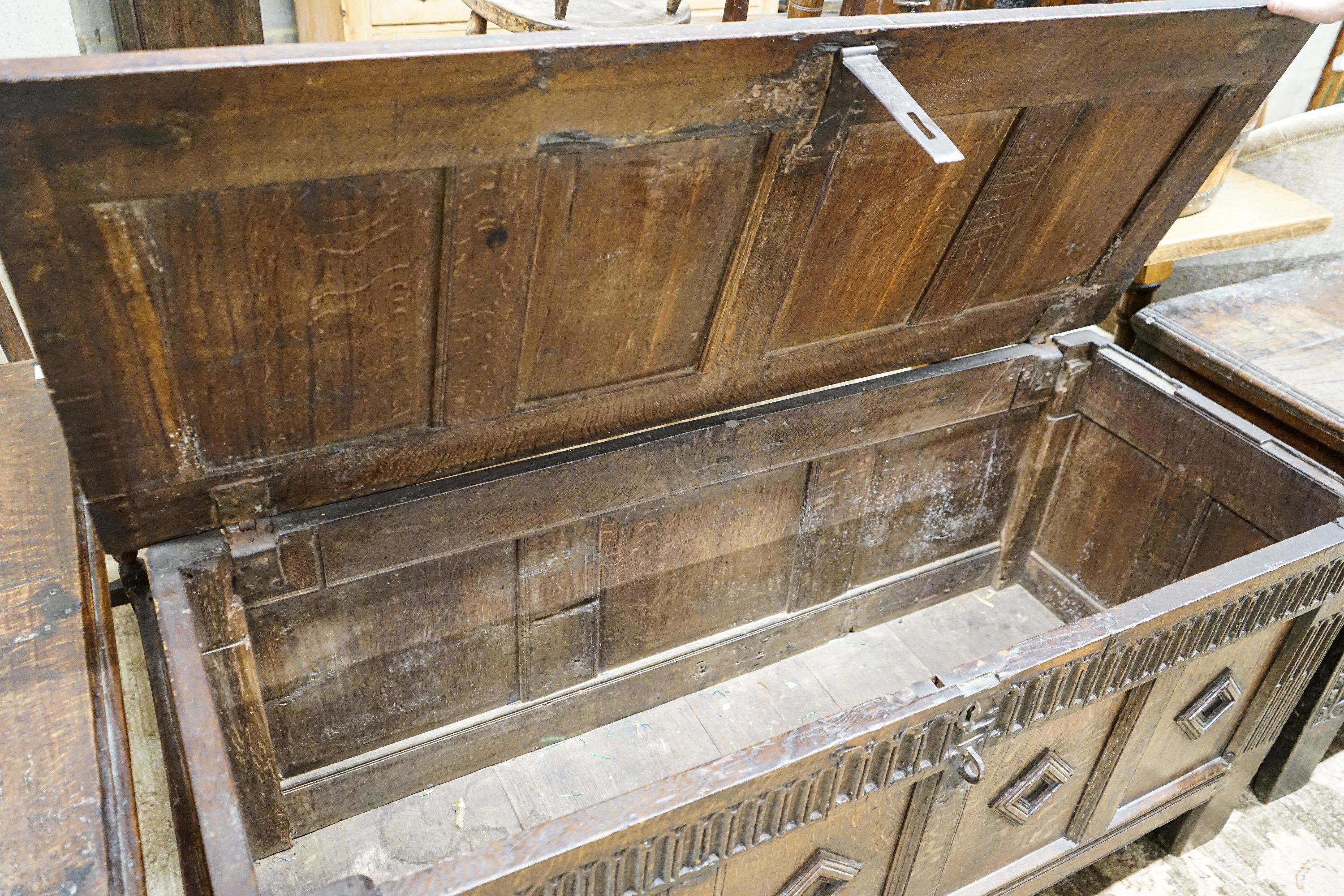 A late 17th century oak coffer, with four panel top and carved front, length 151cm, depth 58cm, height 69cm